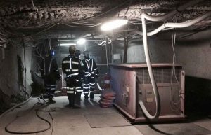 Miners in reflective gear at charging station