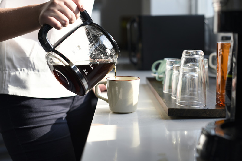 a worker pours coffee in break room