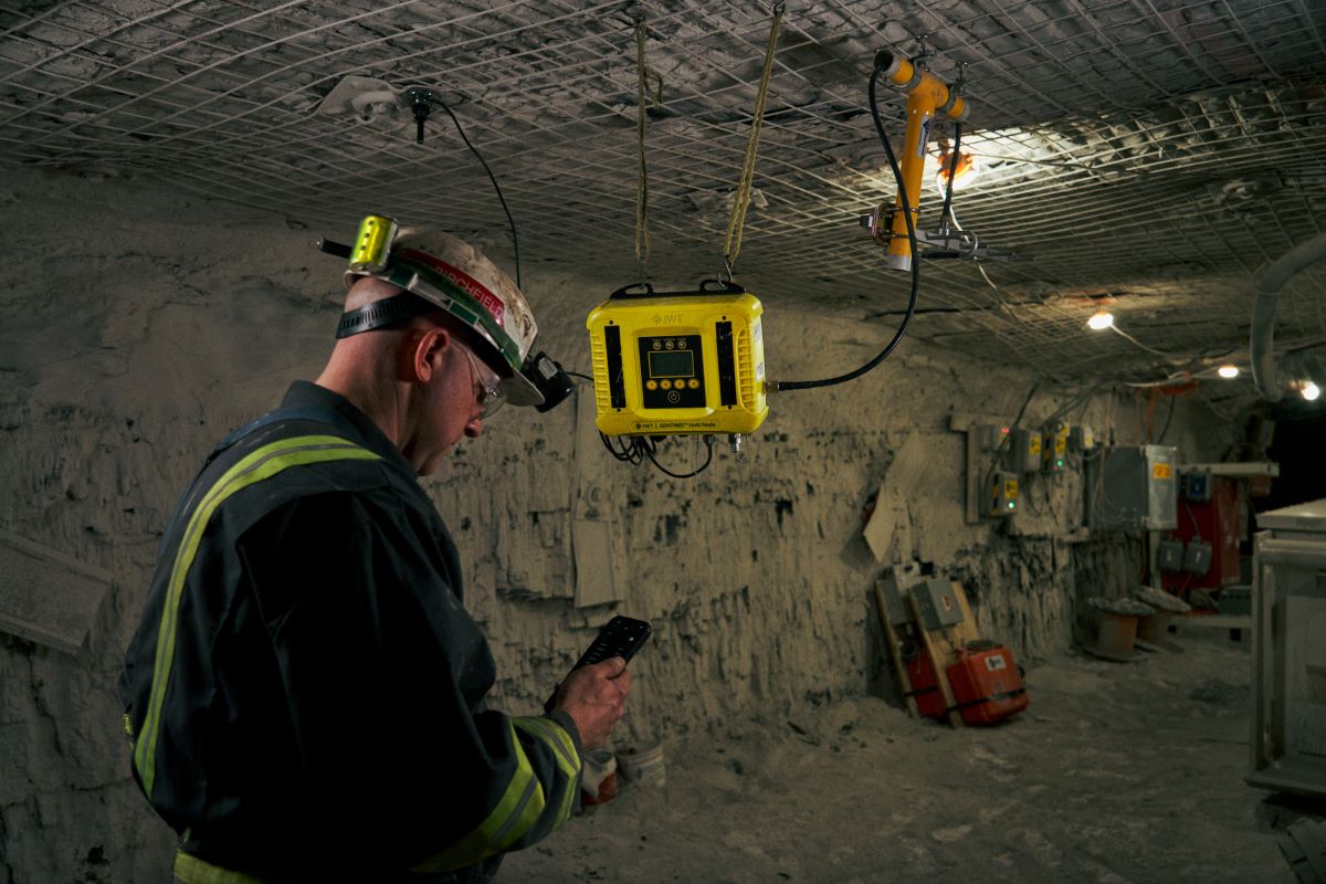 miner in mine looking at handheld device