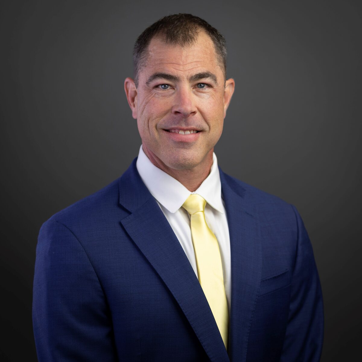 Man in blue suit with yellow tie.